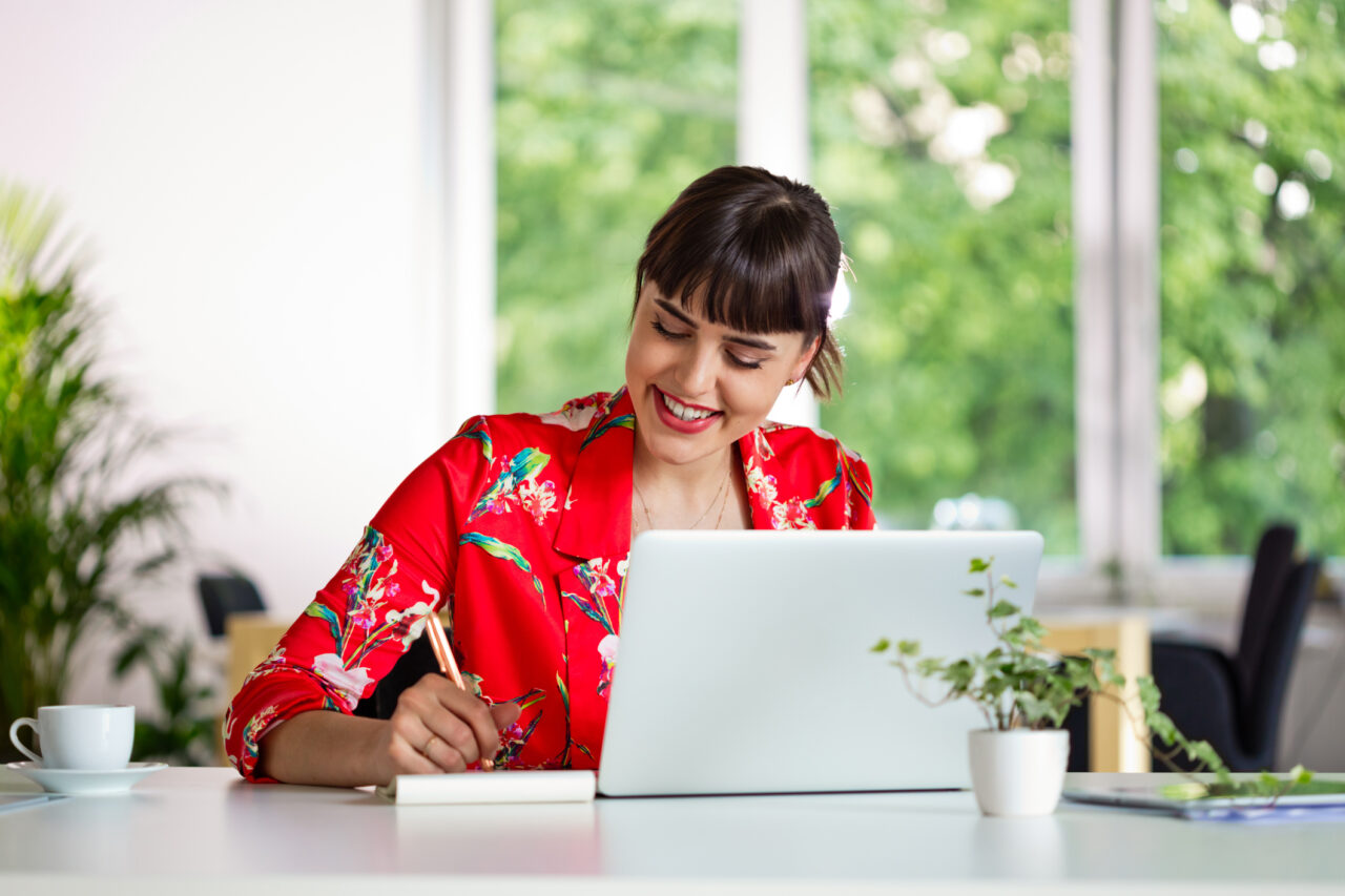 Cheerful young woman working in the eco-friendly green office