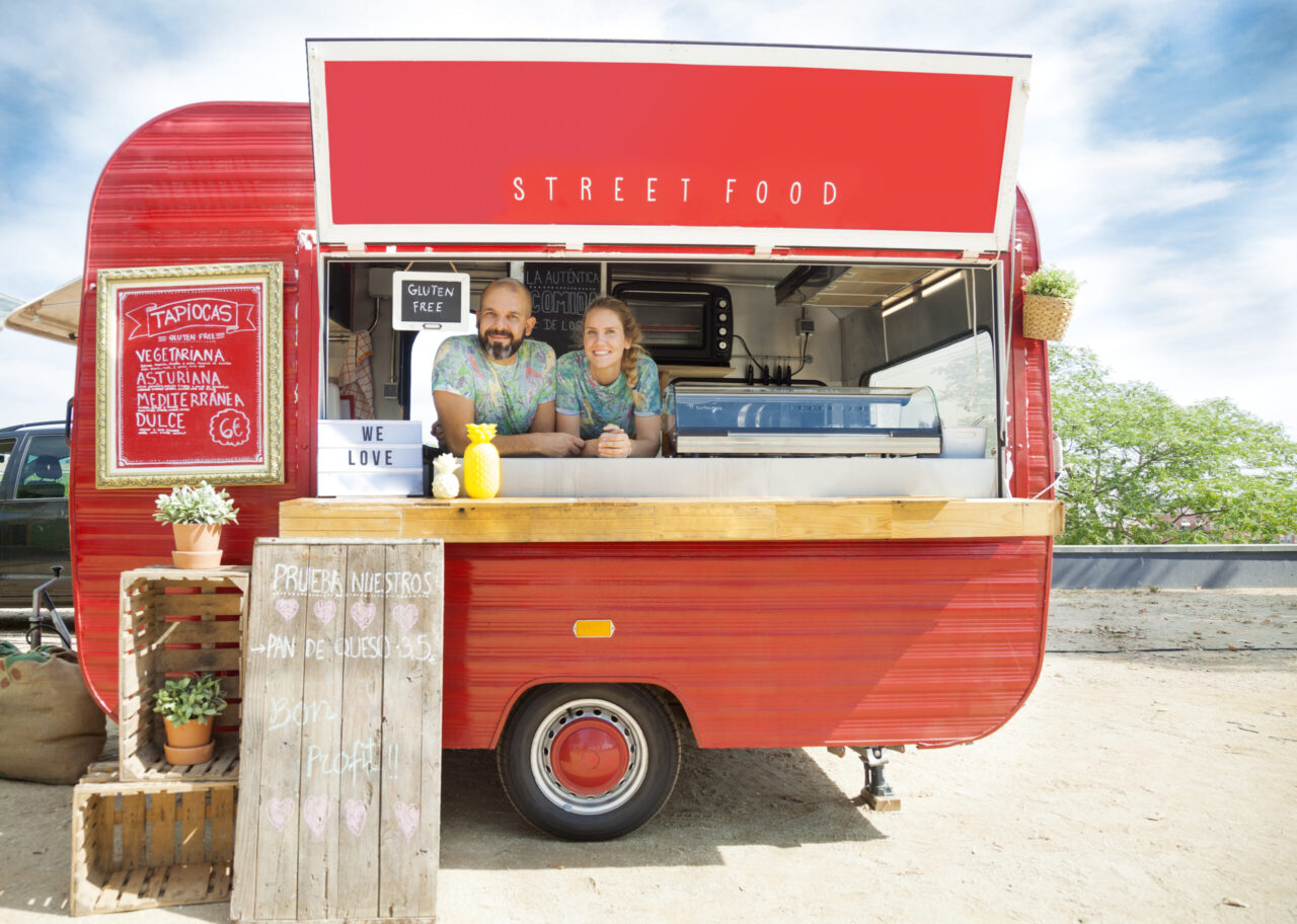 Red food truck and owners young couple